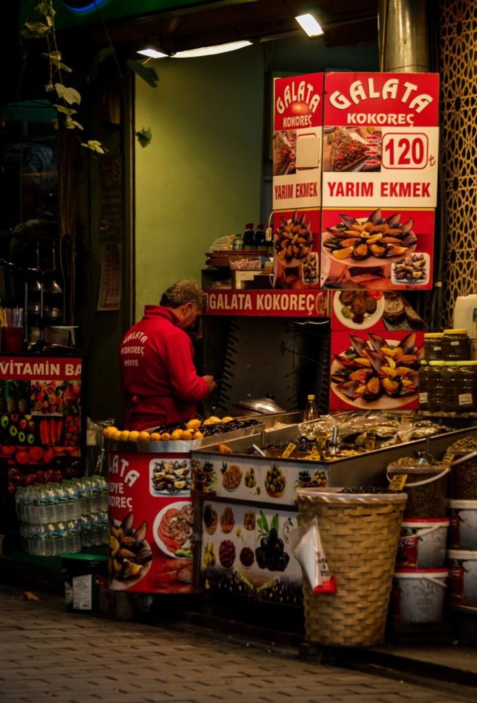 Vibrant Istanbul street vendor selling Kokoreç with colorful signage and local delicacies.