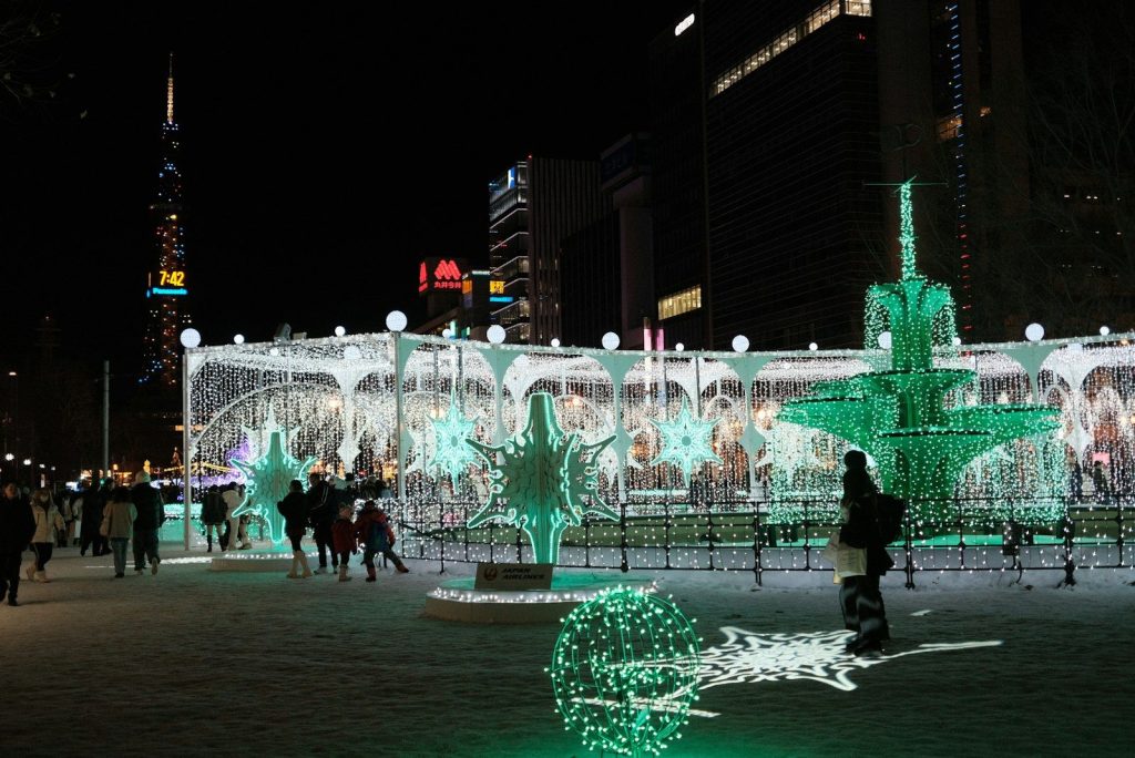 A group of people standing around a lit up fountain
