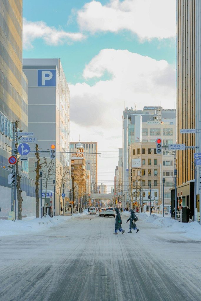 Snowy city street with buildings and pedestrians