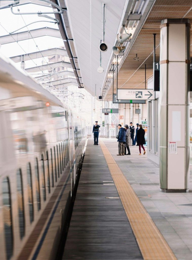 Travelers walking along the platform of a Japanese train station