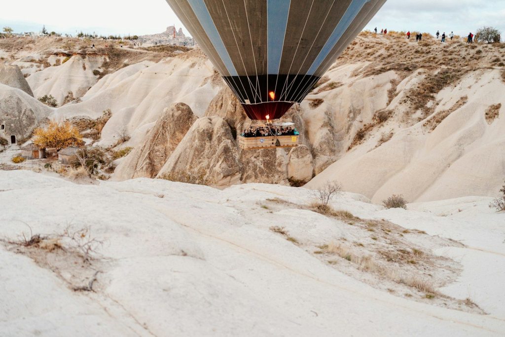A hot air balloon flying over a rocky landscape