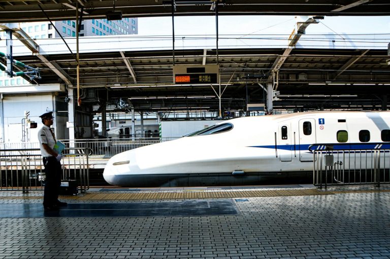 White Shinkansen bullet train waiting at a station platform in Japan