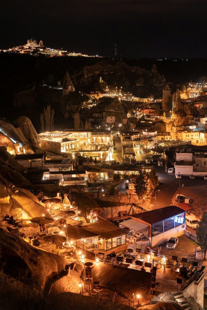 Illuminated buildings and cave dwellings nestled in the rocky landscape of Goreme at night